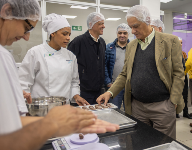 pessoas experimentando biscoito na área de panificação